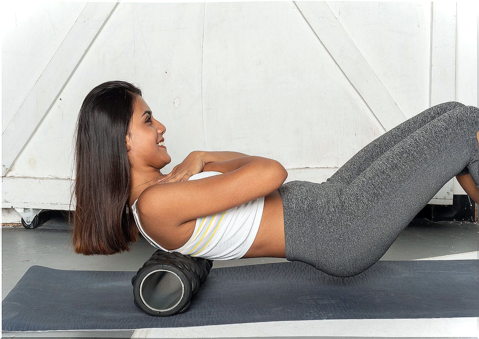 Girl using a foam massager after training.