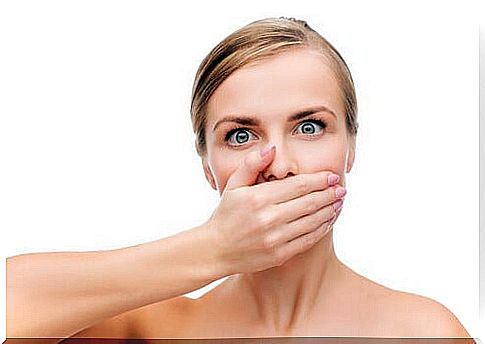 Woman covering her mouth from bad breath