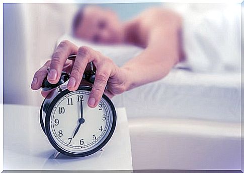 Man turning off the alarm clock