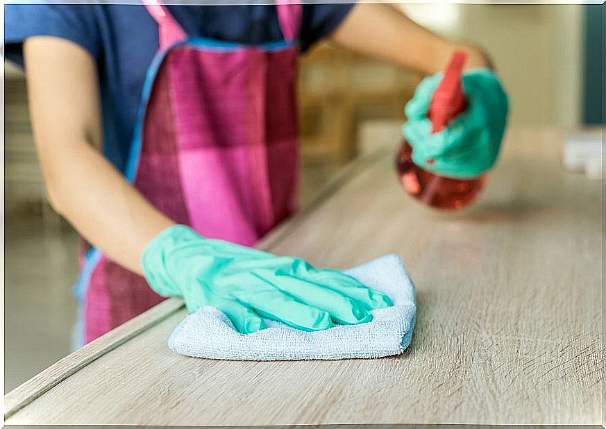 Cleaning a wooden furniture with a spray and a cloth