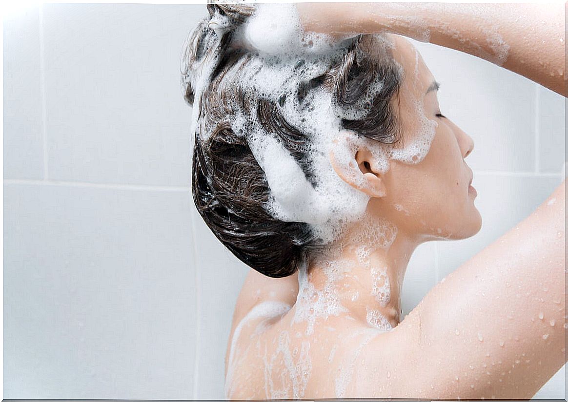 Woman uses shampoo for her hair.