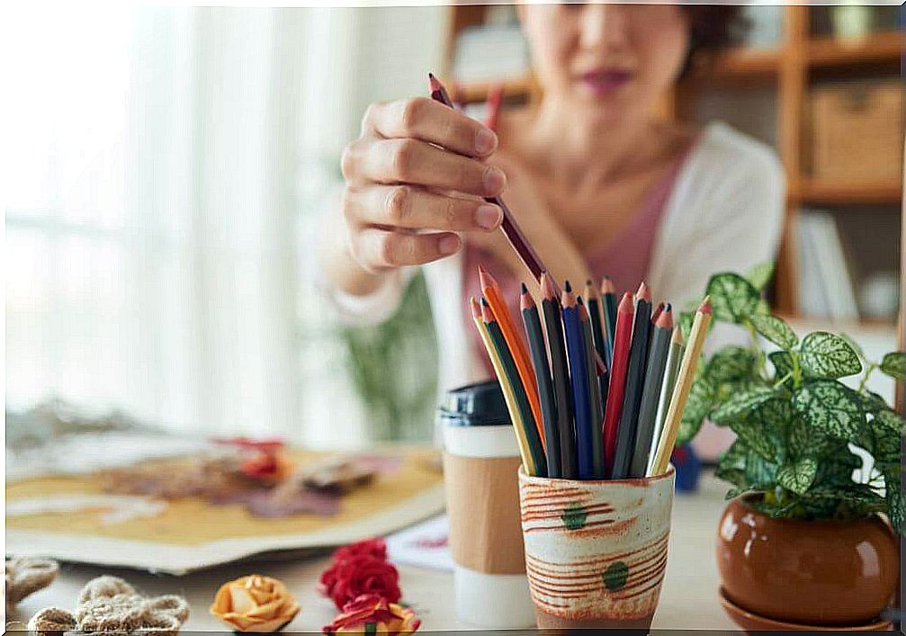 Woman placing pencil in pencil holder