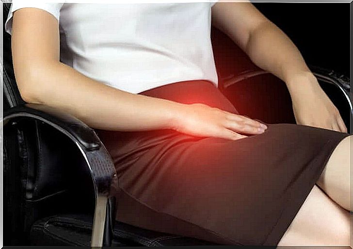 Woman sitting with pain in groin