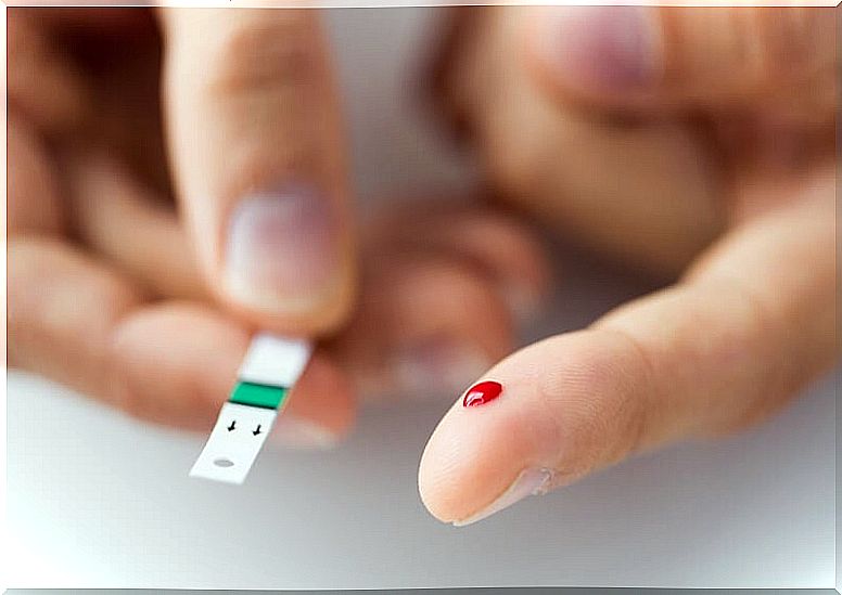 Finger with a drop of blood to do a blood glucose test.