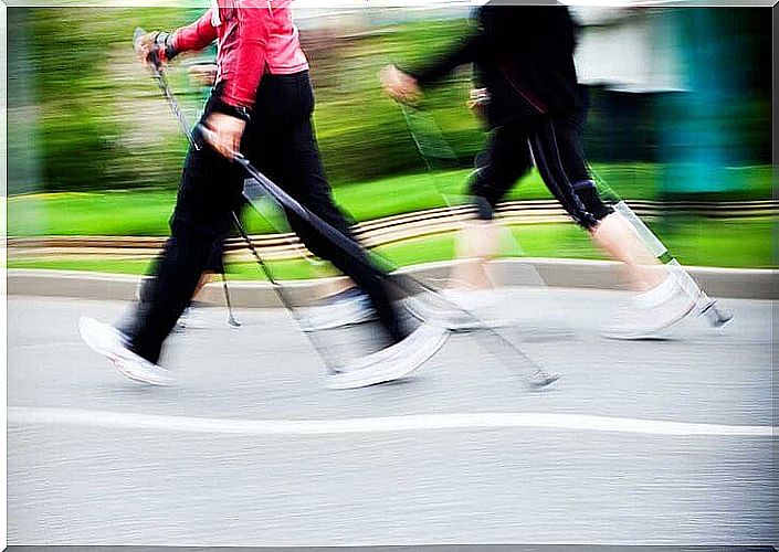 Two people on the move practice Nordic walking on asphalt.