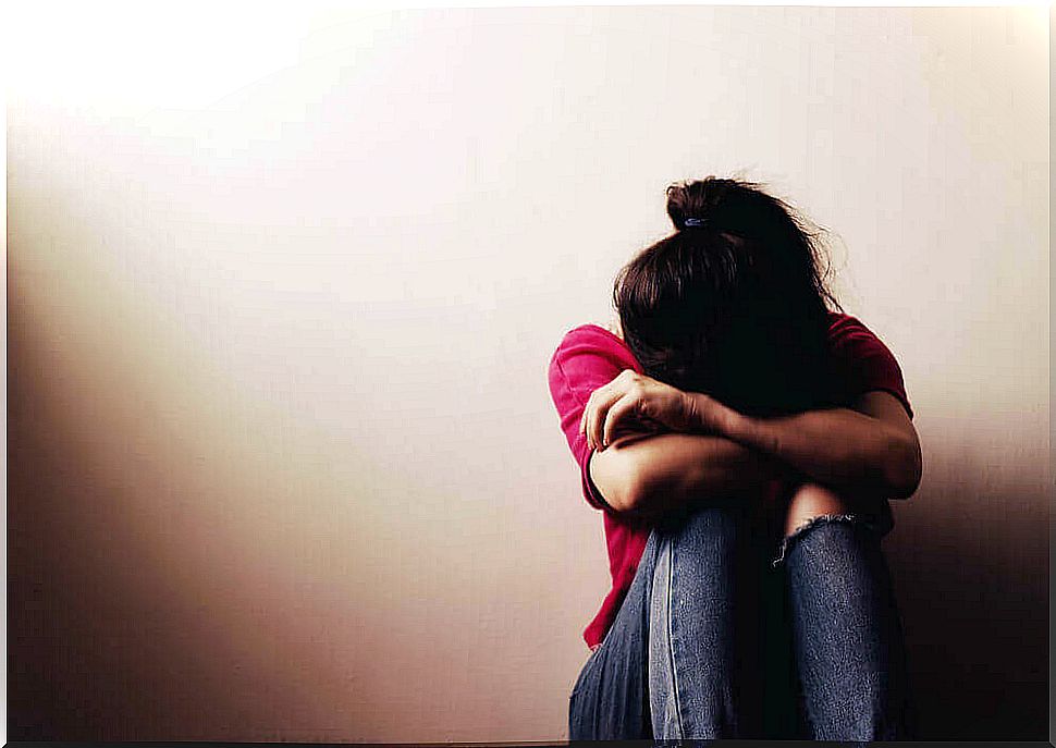 Girl with depression sitting on the floor